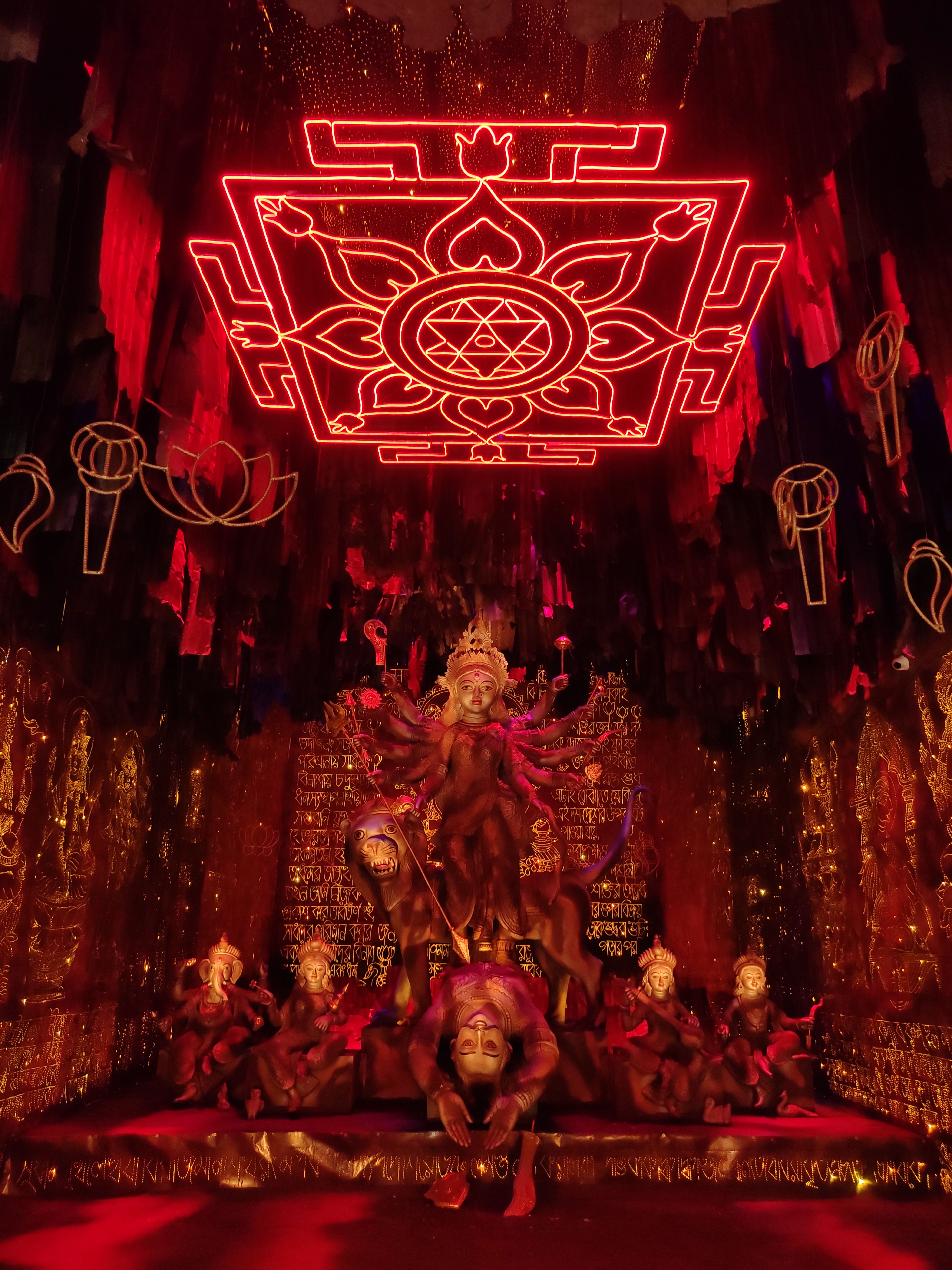 A bronze Durga idol on her lion beneath a glowing red Sri Yantra — photo via Pexels / Subhajit Biswas